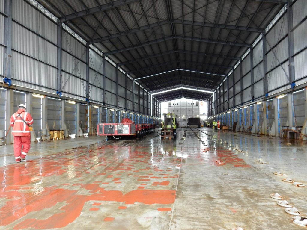 Innenansicht des Ladebereichs eines RoRo-Schiffes mit Schwerlasttechnik und Vorbereitungen für den Transport von Projektladung im Bereich maritimer Schwerlastlogistik und Hafenumschlag – transporttechniker-de