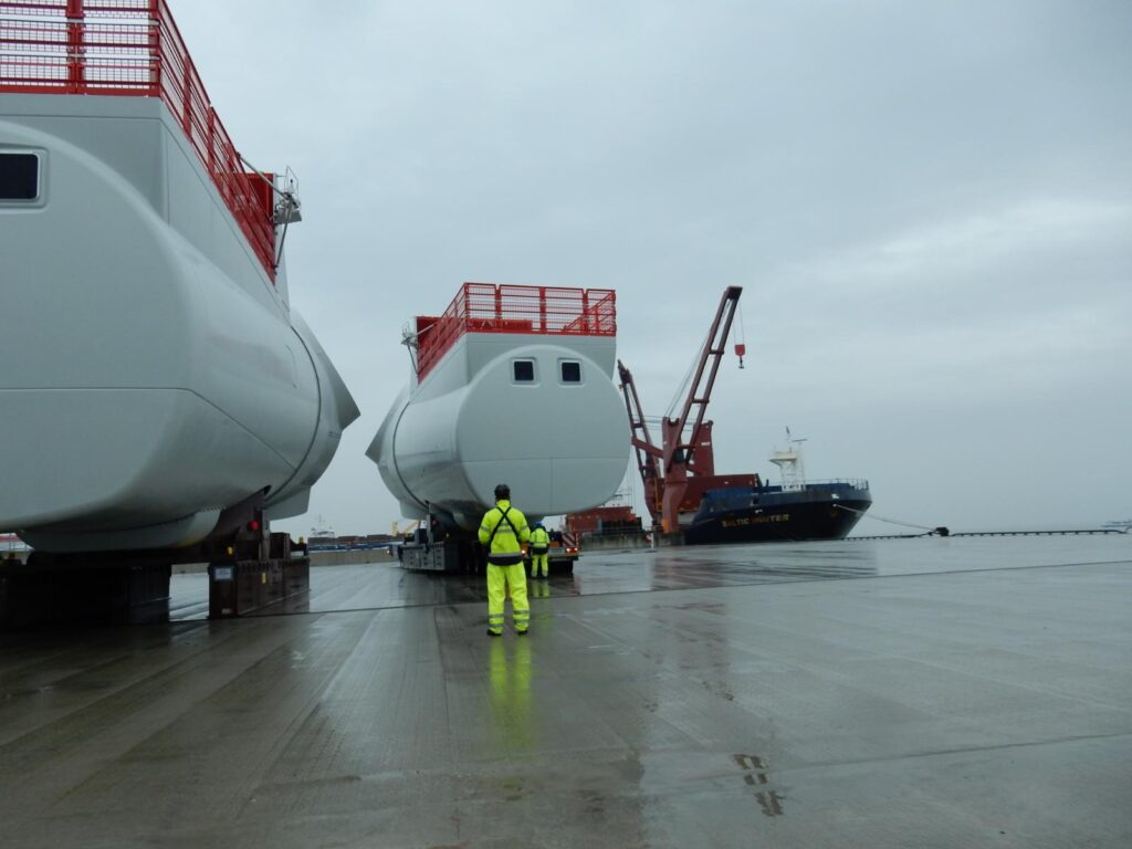 Transport von Gondeln, Nacellen und Maschinenhäusern auf SPMT im Hafenbereich bei Schwerlastlogistik-Operationen mit Kranunterstützung und maritimer Verladung – Projektbeispiel von transporttechniker.de im Bereich Schwertransport und Industrieumschlag