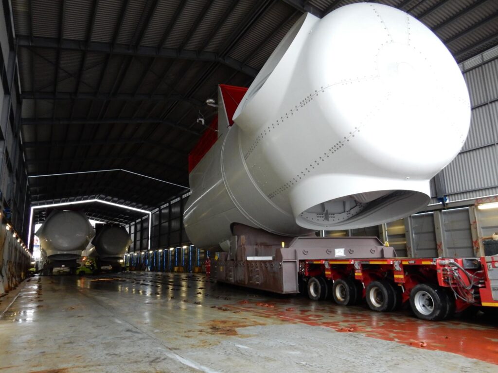 Transport einer Windkraft-Gondel (Nacelle) auf einem SPMT in einer Industriehalle – transporttechniker-de