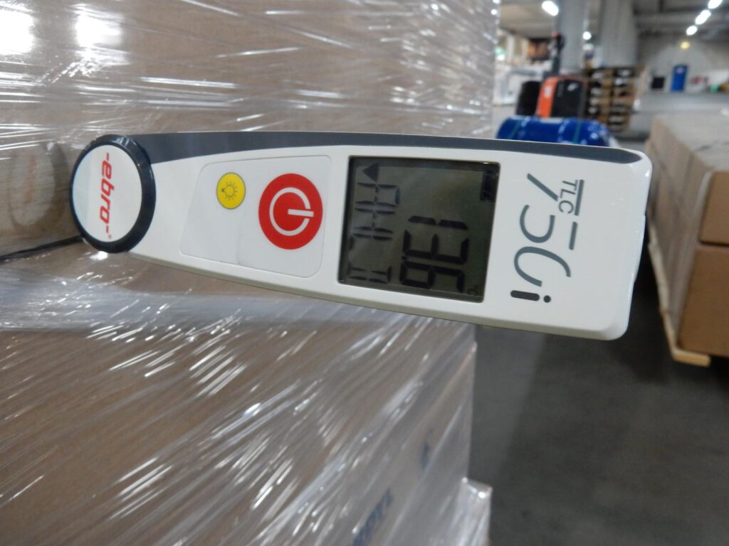 Digitales Industriethermometer EBRO TLC 75i zur Temperaturüberwachung im Tiefkühllager – zwischen Kartons auf einer Palette platziert, mit Display und Bedienelementen