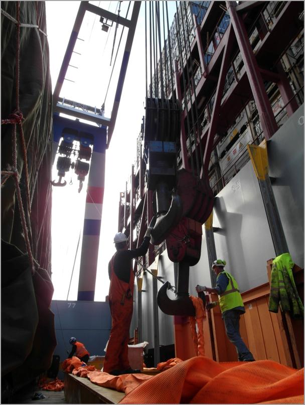Foto eines Containerschiffs mit Portalkran und Arbeitern beim Schwerlastumschlag