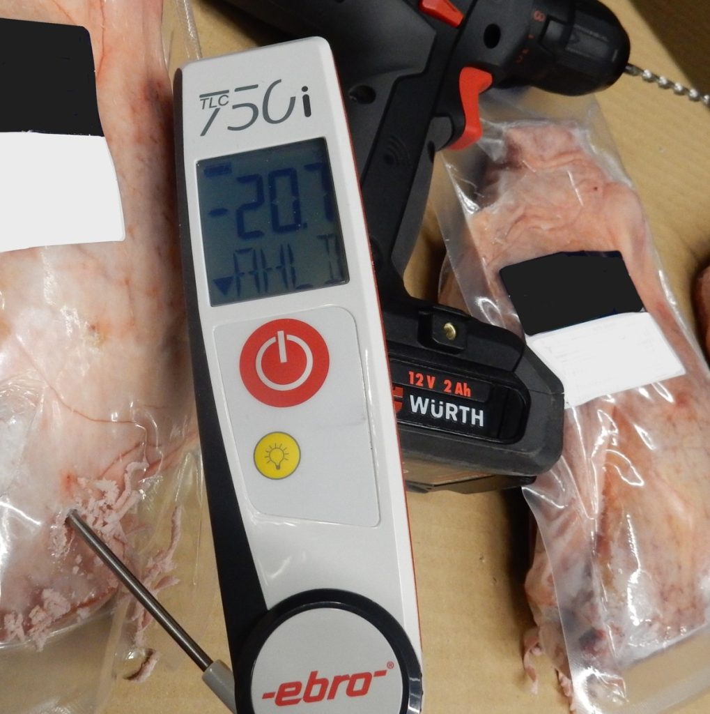 Temperaturmessung von vakuumverpacktem Fleisch mit digitalem Thermometer (Ebro TLC750i) – Akkuschrauber und weitere Fleischstücke im Hintergrund.