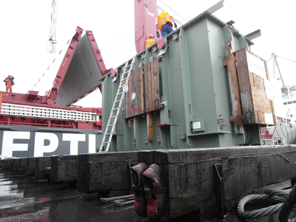 transformator-auf Schwimmkran-Hintergrund vessel-arbeiter-orange-schutzausruestung