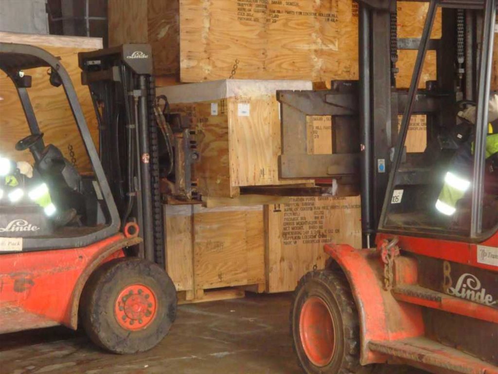 Gabelstapler transportieren Holzkisten in Lagerhalle – transporttechniker.de