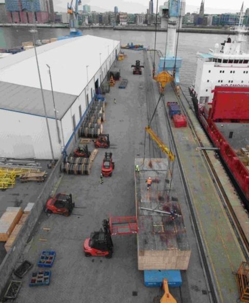 Kran lädt Stahl-Coils im Hafen mit Gabelstaplern – transporttechniker.de