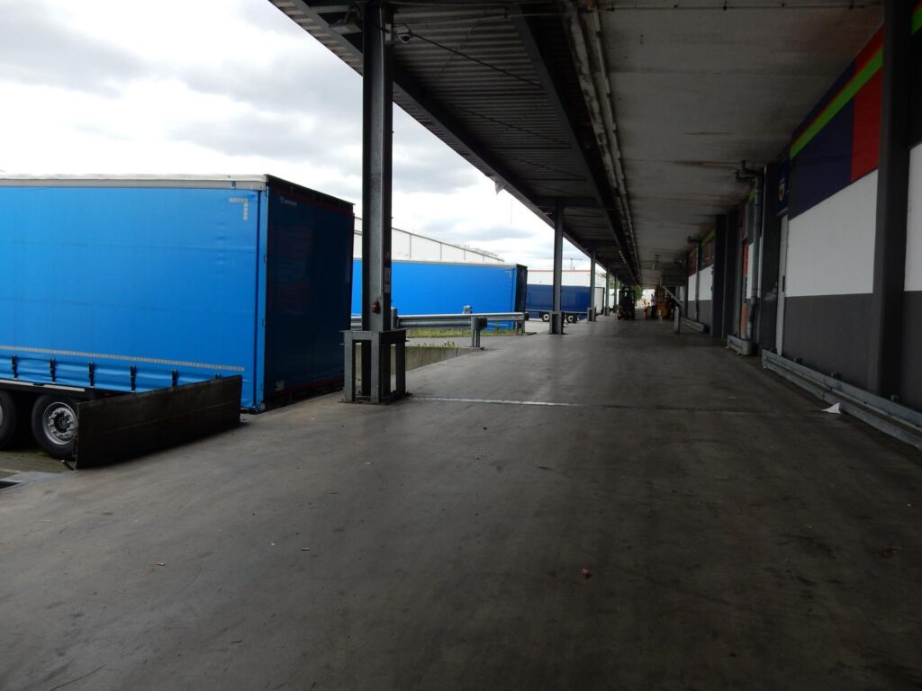 Lagerhalle mit blauem Lkw – Verladung unter Überdachung – transporttechniker.de