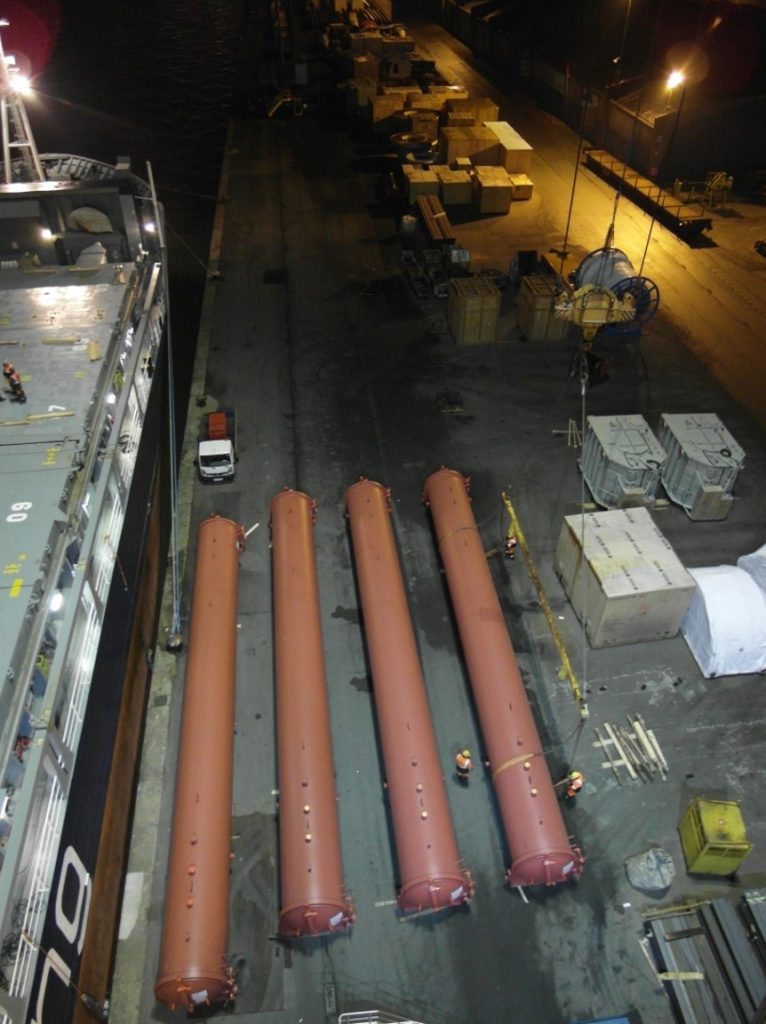 Lange Zylinder auf Schiffsdeck im Hafen bei Nacht – transporttechniker.de