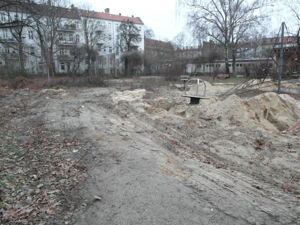 Spielplatz in Berlin während der Bauphase mit Sandfläche, Baustellenabsperrung und altem Klettergerüst – transporttechniker.de