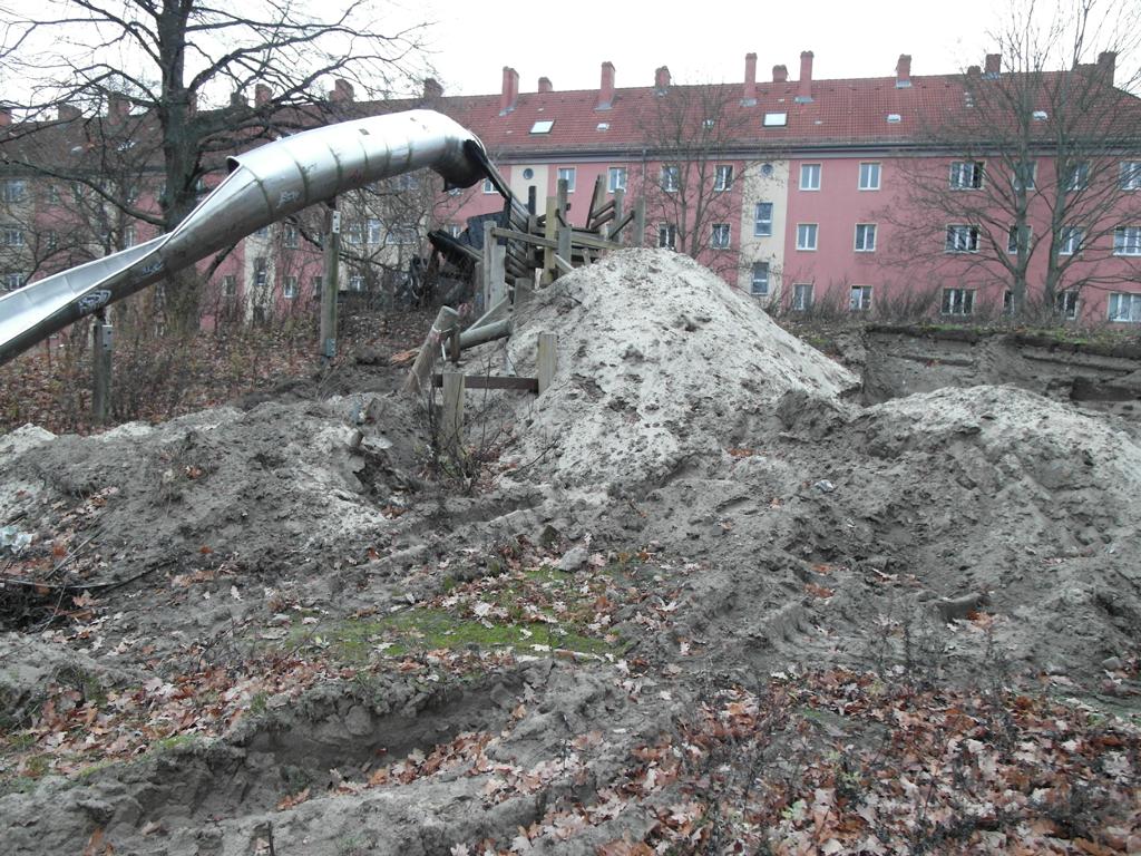 Spielplatz in der Dusekestraße, Berlin – Bauphase mit Rutsche, Sandhaufen und Wohnhäusern im Hintergrund – transporttechniker.de