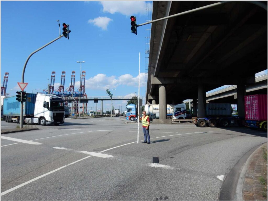Route Survey mit Ampelhöhenausmessung für Schwerlasttransport an Kreuzung unter Brücke im Hafenbereich – transporttechniker-de