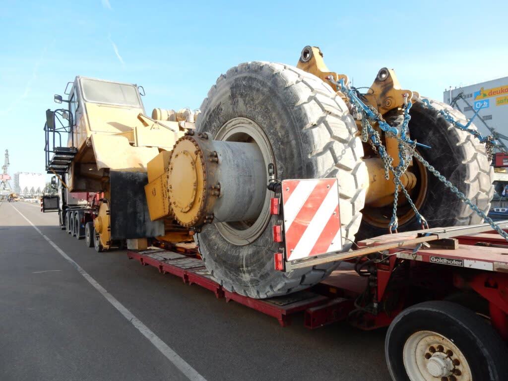 Schwerlasttransport eines Radladers mit gesicherten Reifen auf Tieflader – transporttechniker-de